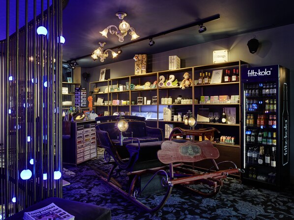 Ein Zimmer mit Bücherregal, einem alten Schaukelstuhl und einer Minibar.