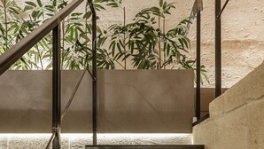 A staircase with metal railings and a concrete wall. - Hydria Residence (Matera)