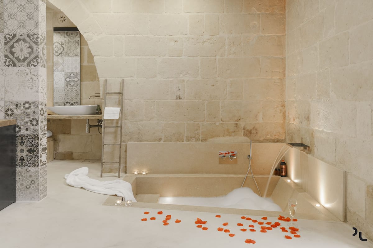 A bathroom with a bathtub, a sink, and a shower area.