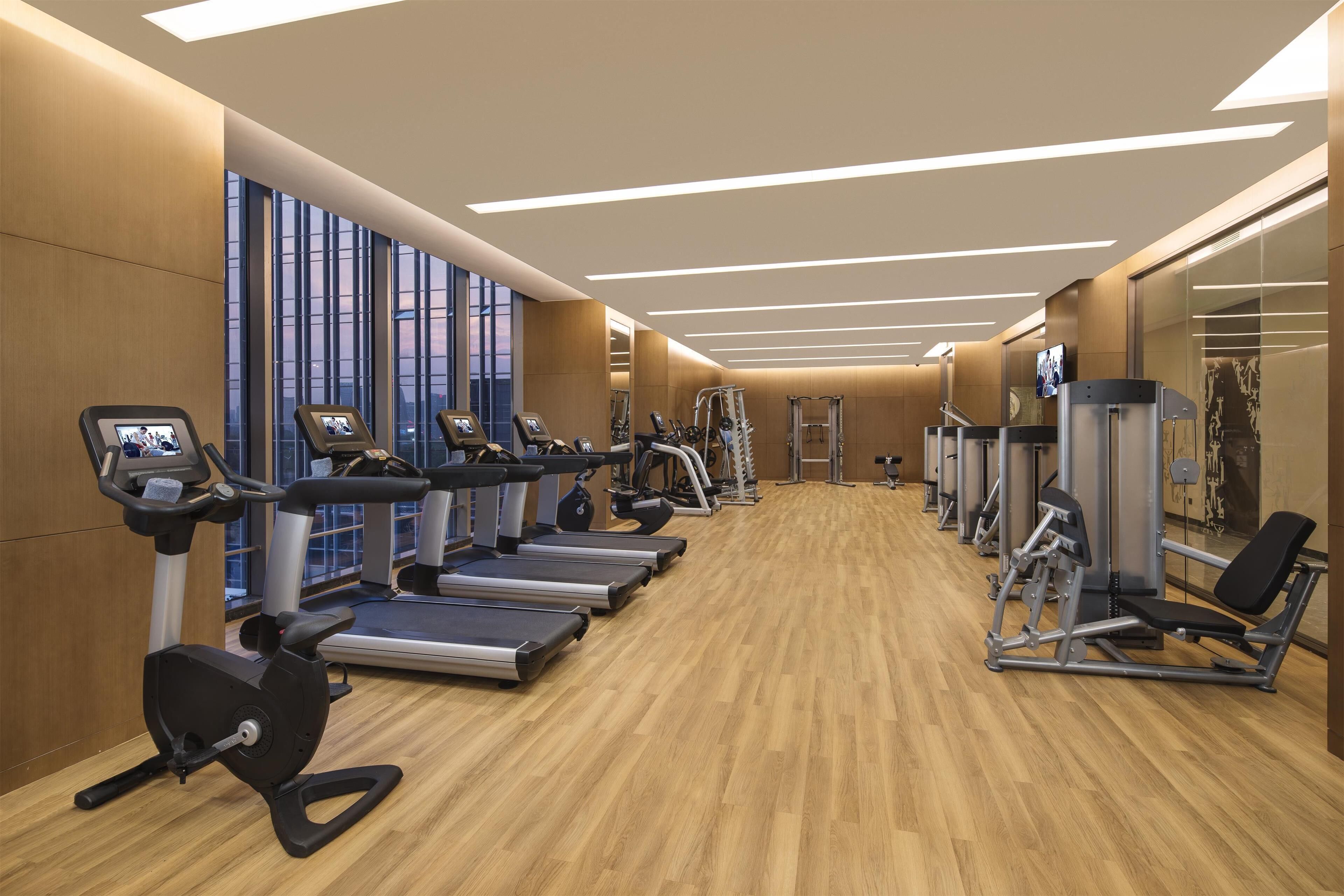 A gym with treadmills, elliptical machines, and weight equipment.