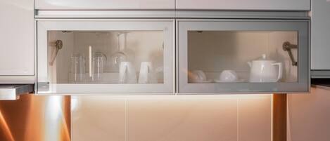 Una cocina con dos armarios de vidrio que contienen utensilios de cocina.