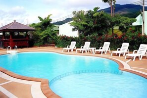 A swimming pool with lounge chairs and a gazebo. - Baantonsai Garden Resort (Phuket)