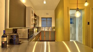 A modern kitchen with stainless steel appliances, a built-in wine cooler, and pendant lighting. - Langholm (Cape Town)
