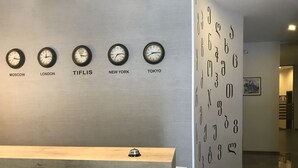 Een receptie met klokken die de tijd weergeven voor Moskou, Londen, Tbilisi, New York en Tokio.