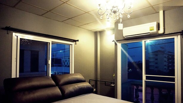 A modern hotel room with a bed, a chandelier, and large windows. - Staying Hostel (Bang Phli)