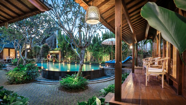 A wooden deck with a pool, surrounded by lush greenery and a covered seating area. - Yana Villas Kemenuh by GenuineHost (Sukawati)