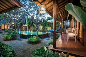A wooden deck with a pool, surrounded by lush greenery and a covered seating area. - Yana Villas Kemenuh by GenuineHost (Sukawati)