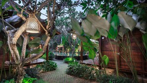 A garden pathway leading to a wooden structure with a hanging light fixture. - Yana Villas Kemenuh by GenuineHost (Sukawati)
