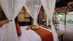 A bedroom with a large bed, white canopy, and a view of an outdoor pool area. - Yana Villas Kemenuh by GenuineHost (Sukawati)
