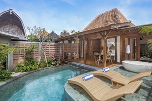 A pool with lounge chairs, a wooden deck, and a covered seating area. - Yana Villas Kemenuh by GenuineHost (Sukawati)