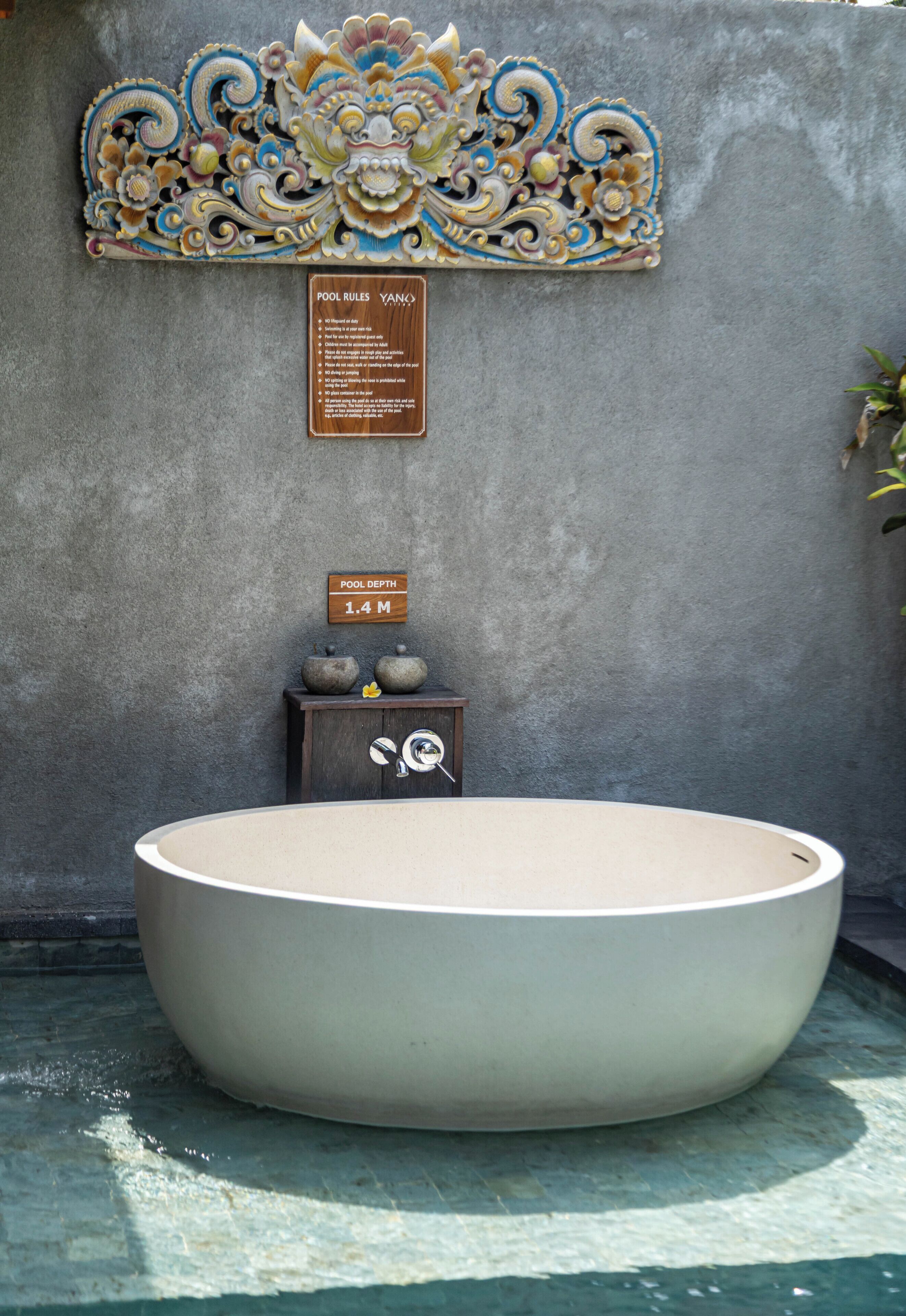 A large freestanding bathtub with a sign indicating a depth of 1.4 meters.