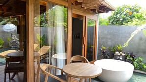 A wooden interior with a glass door leading to a garden area. - Yana Villas Kemenuh by GenuineHost (Sukawati)