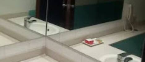 Ein Badezimmer mit großem Spiegel, Waschbecken und Toilette.