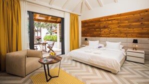 A hotel room with a bed, a chair, a small table, and a wooden wall. - Villa Diamond (Zupa dubrovacka)