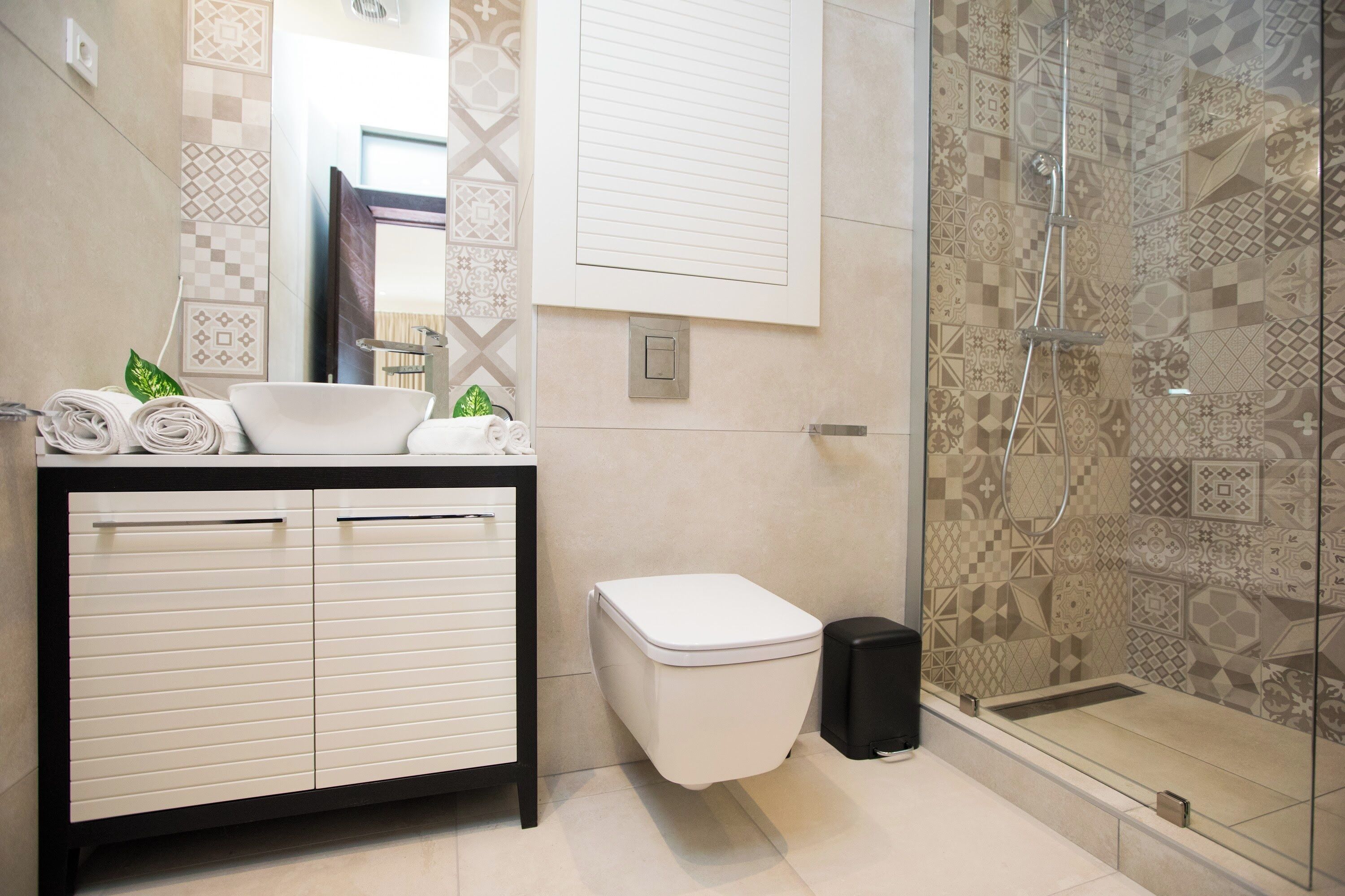 Un baño moderno con lavamanos, inodoro y ducha.