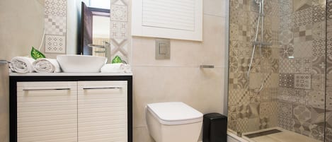 A modern bathroom with a sink, toilet, and shower.