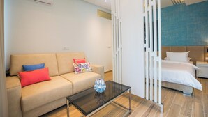 A modern hotel room with a sofa, a glass coffee table, and a bed. - Villa Diamond (Zupa dubrovacka)