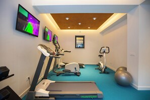 A fitness room with exercise equipment, a treadmill, and a large exercise ball. - Villa Diamond (Zupa dubrovacka)