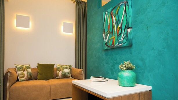 Una sala moderna con un sofá, una mesa de centro y un cuadro abstracto colgado en la pared.
