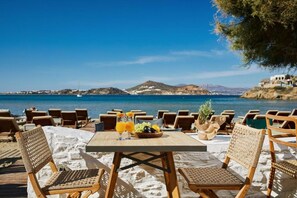 A beachside dining area with a table set for two, overlooking the sea. - Kalergis Studios (Naxos)