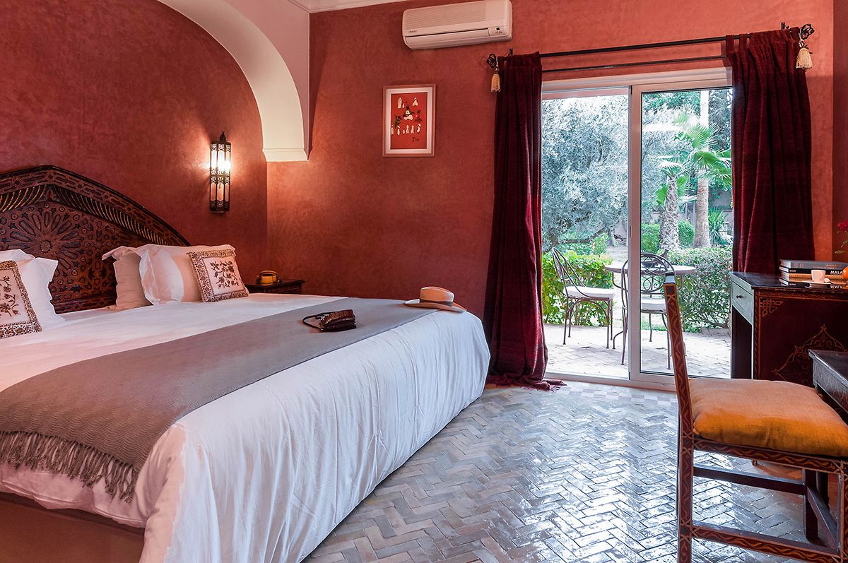 Quarto de hotel com uma cama grande, uma escrivaninha e vista para o exterior.
