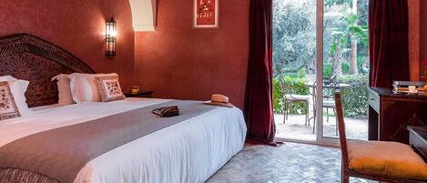 Quarto de hotel com uma cama grande, uma escrivaninha e vista para o exterior.
