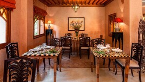 A dining area with a wooden ceiling, a chandelier, and a table set for six with chairs. - Villa Des 3 Golfs (Marrakech)