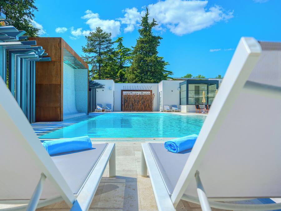 Una piscina al aire libre de temporada, tumbonas