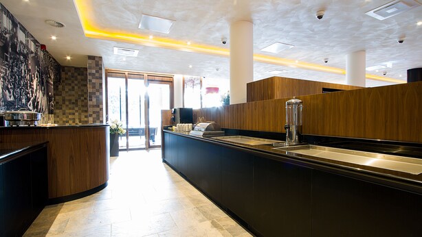 A modern kitchen with a central island, a sink, and a coffee machine.