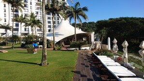 Un resort con piscina, palmeras y un edificio moderno de diseño arquitectónico único.