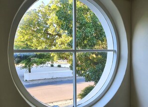 A window with a view of a tree and a building in the background.