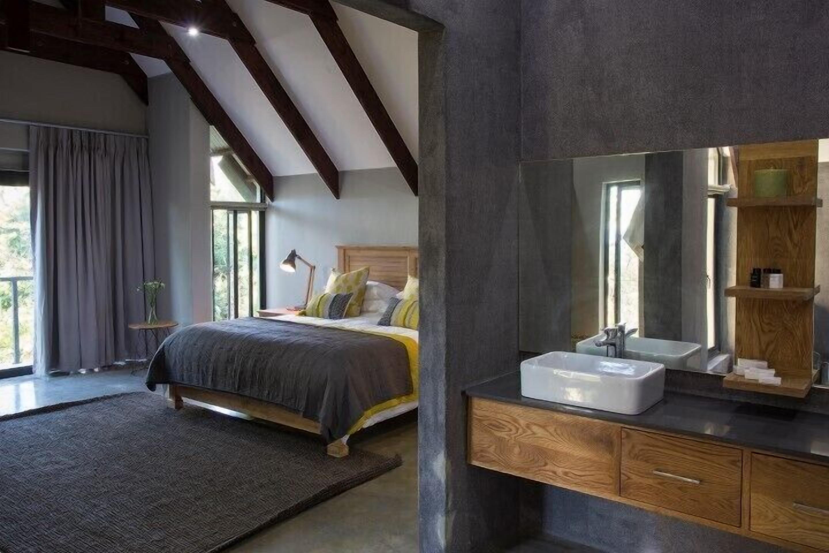 A modern bedroom with a large bed, a bedside table, a mirror, and a built-in wooden cabinet.