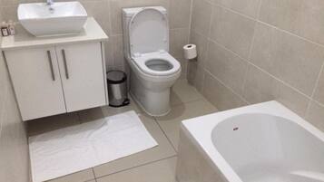 A bathroom with a sink, toilet, and bathtub.