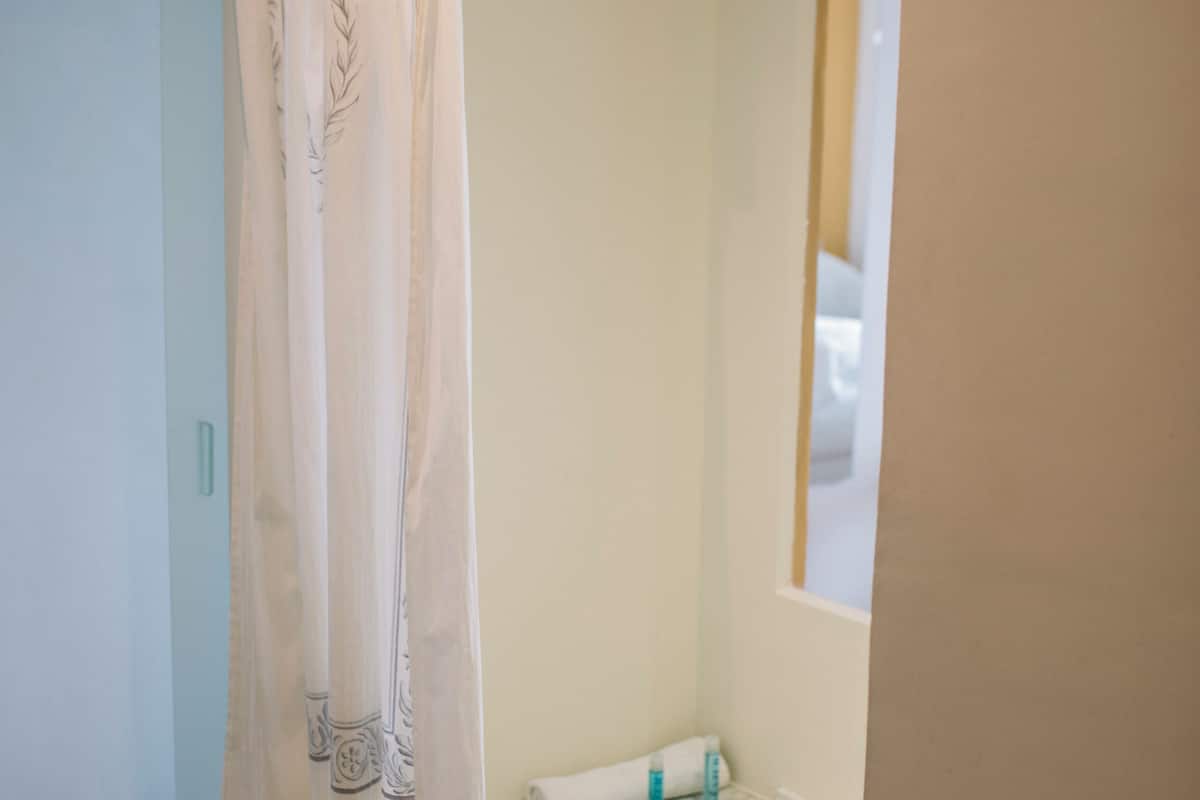 A bathroom with a bathtub, a shower curtain, and a towel rack.