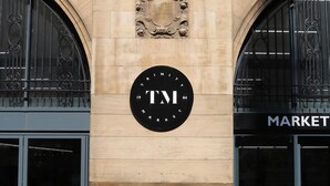 A building facade with a large circular sign reading "TM MARKET" and two arched windows with metal grilles. - Hideout Apartment Hotel (Hull)