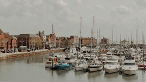 A marina with numerous boats docked along a waterfront, surrounded by buildings. - Hideout Apartment Hotel (Hull)