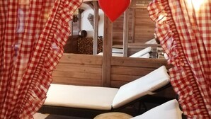 A cozy room with checkered curtains, a heart-shaped decoration, and wooden furniture. - Burg Hotel (Feldberg)
