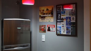 A kitchen with a refrigerator, a wall-mounted light, and various travel posters. - Copacabana Guest House (Rio de Janeiro)
