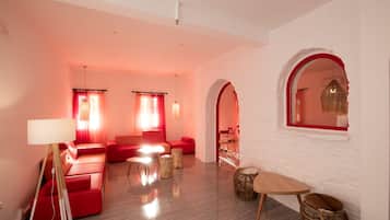 Una sala de estar moderna con un sofá rojo, una lámpara de pie y una mesa redonda.