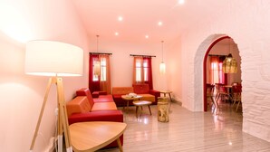 Una sala de estar moderna con sofás rojos, una mesa de centro de madera y una lámpara.