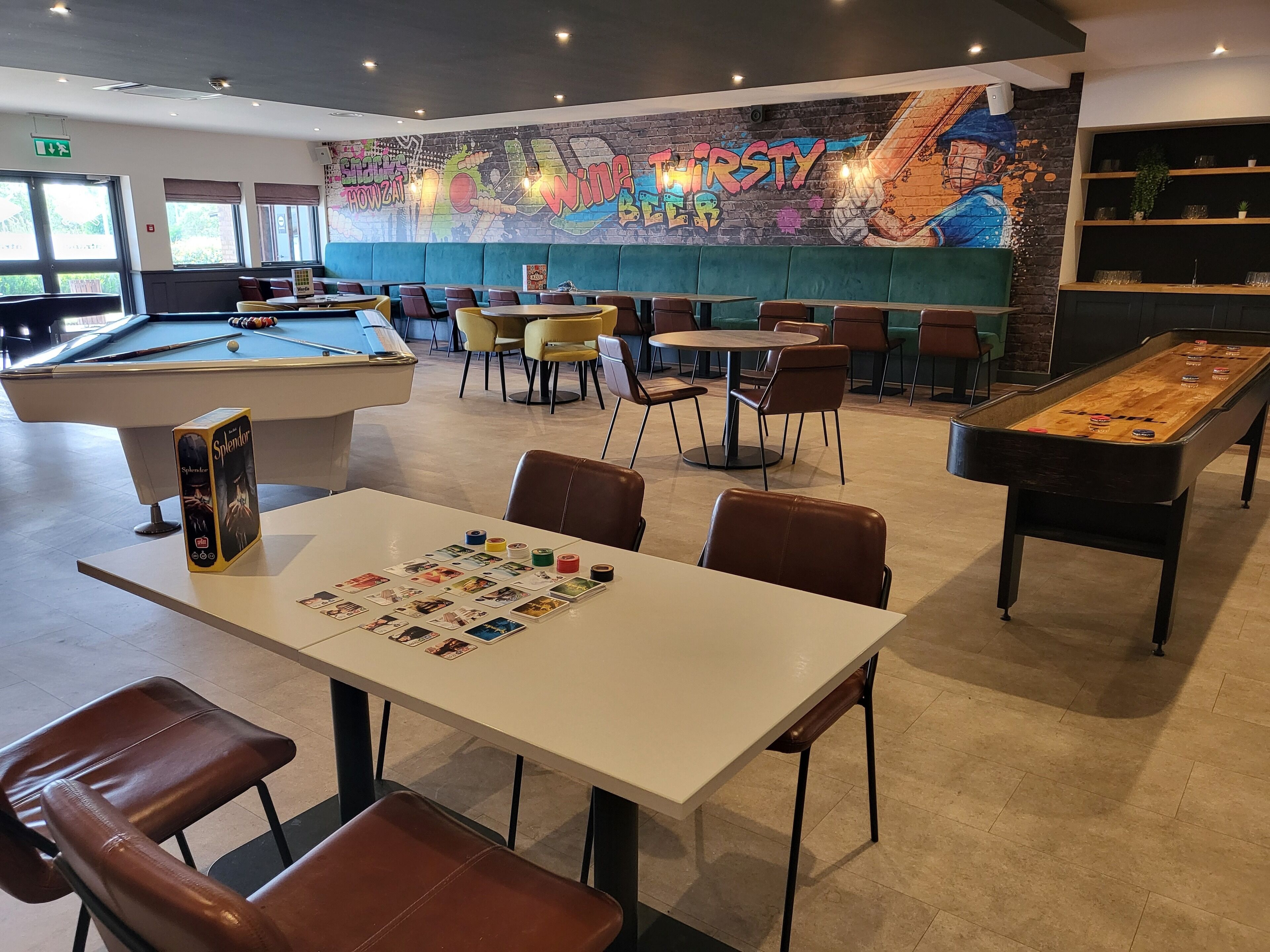 A billiards room with tables, chairs, and a pool table.