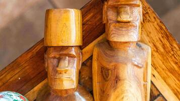 Two wooden sculptures with carved faces on a wooden table.