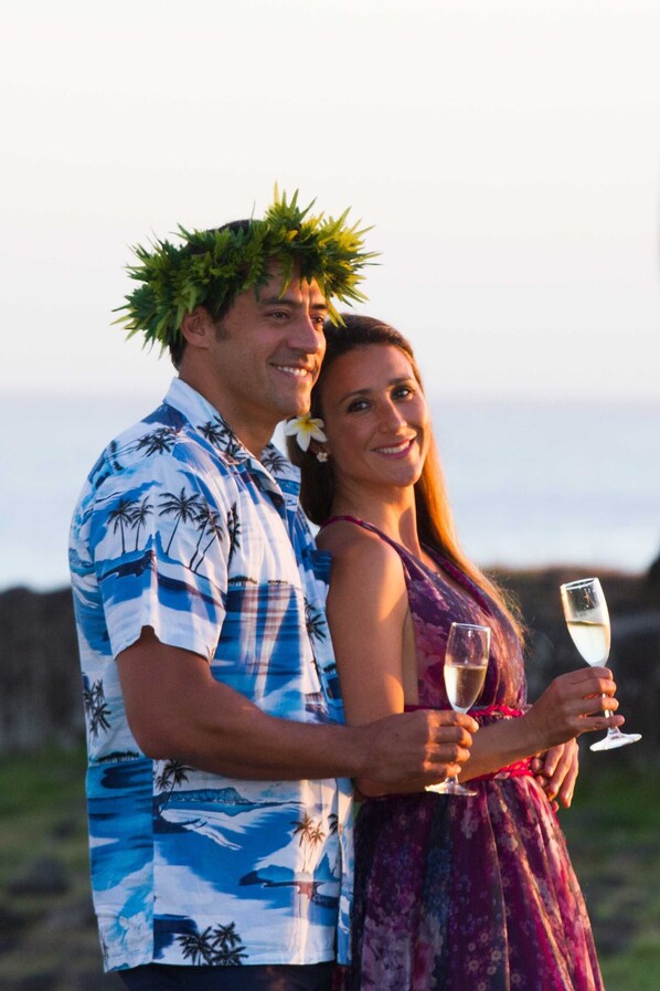 A couple standing outdoors, holding champagne glasses.