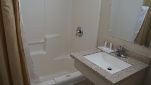 A bathroom with a white sink, a mirror, and a shower door. - Best Stay Inn (Plainville)