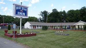 A Best Stay Inn with a single-story structure, a covered front porch, and a well-maintained lawn with flower beds. - Best Stay Inn (Plainville)
