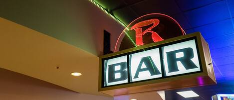 A neon sign with the letters "BAR" and a partial "R" indicating a bar or restaurant.