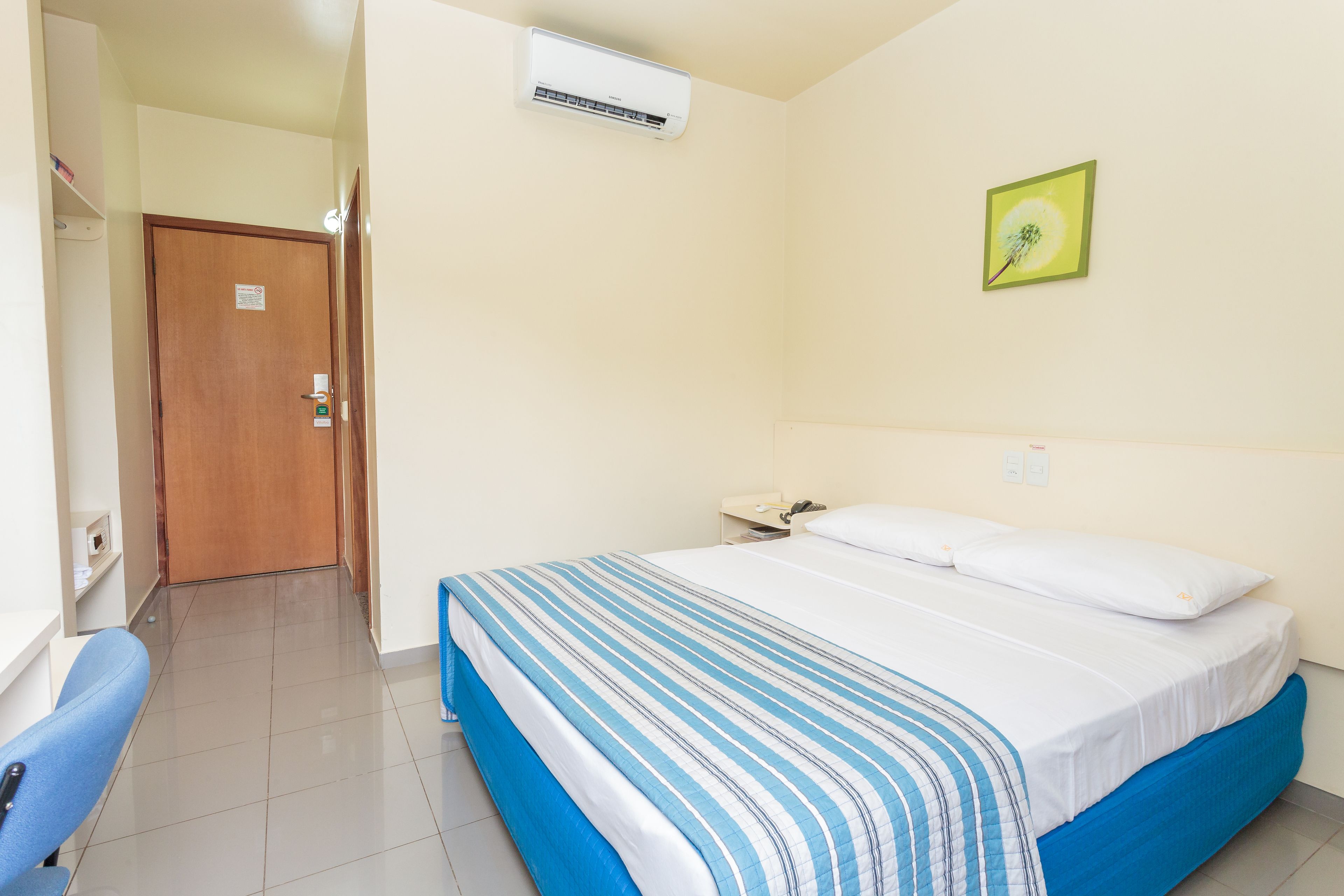 Una camera d'albergo con un letto, una scrivania e una sedia.