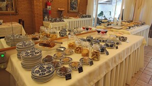 Una mesa de buffet con diversos alimentos y platos, incluyendo platos, frascos y cuencos.