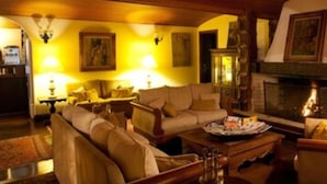 Una sala de estar acogedora con chimenea, asientos cómodos y una mesa de comedor.