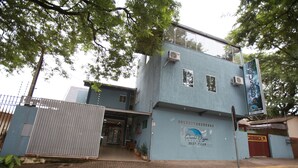 Ein Gebäude mit blauer Fassade, ein Schild mit dem Namen 'Pousada' und eine Telefonnummer '3027-2249'.